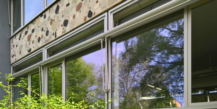 Fensteransicht eines flachen Schulgebäude sehr nah. Ein Fenster ist geöffnet.