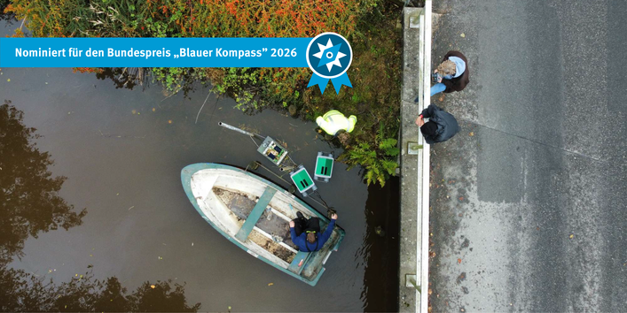 Das Bild zeigt aus der Vogelperspektive die Installation einer Nala-Wassersonde. Ein Angler und ein Ingenieur lassen die Sensortechnik vom Boot aus ins Wasser, während Projektbeteiligte auf der Brücke die Arbeiten begleiten.