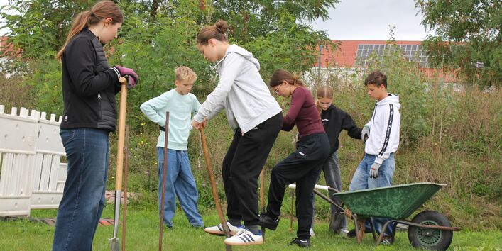 Das Bild zeigt einen Teil der Projektgruppe beim ersten Spatenstich für das Fundament.