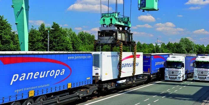 Paneuropa Anhänger werden von einem grünen Kran auf von Schienen auf die Straße verladen