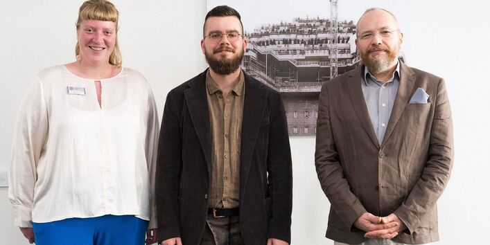 Die Erziehungswissenschaftlerin Alexandria Krug, der Künstler Marcel van Beek und der Umweltökonom Prof. Dr. Erik Gawel bei der Vernissage der Kunstausstellung „Urbs Accommodata“ in der Universitätsbibliothek Leipzig im Oktober 2024