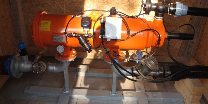 Auf dem Bild sieht man ein zylindrisches Gerät, welches den Feinfilter darstellt. Die Farbe ist orange. Verschiedene Zu- und Ableitungen sowie Messgeräte sind außen am Gerät zu sehen.