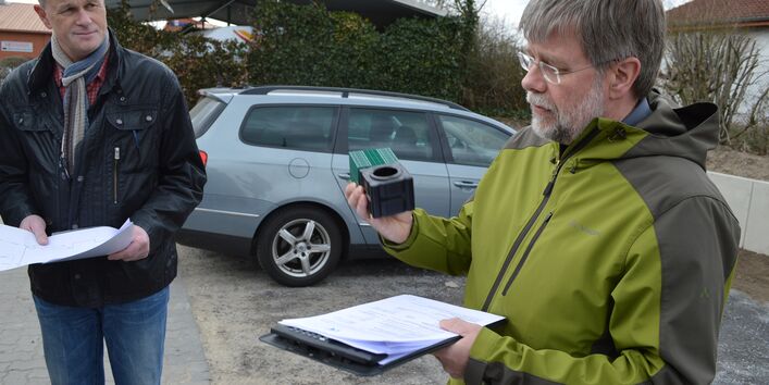 Ein Mann erklärt der Gruppe die Funktionsweise einer Rigole, welche er in der Hand hält