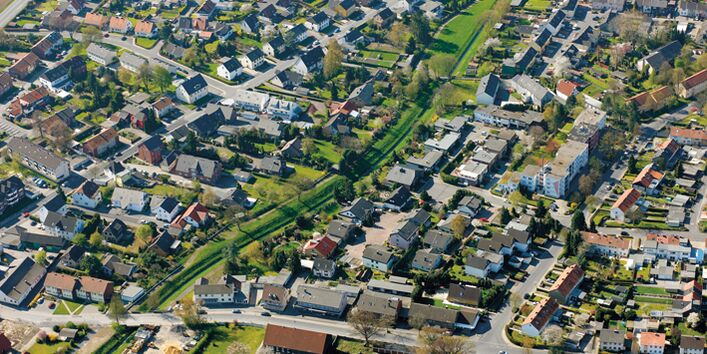 Luftbild einer Siedlung. In der Mitte des Bildes verläuft ein grüner Korridor.
