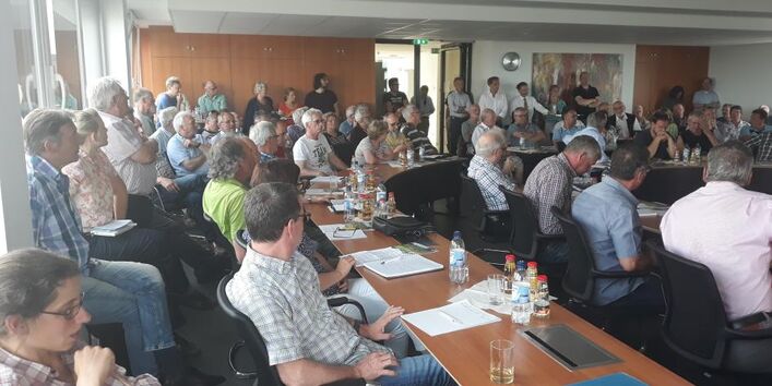 mehreren Personen sitzen und stehen in einem Veranstaltungsraum