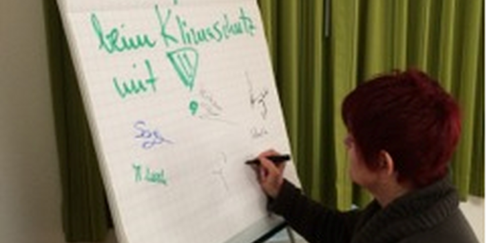 Eine Frau schreibt etwas auf eine Flipchart