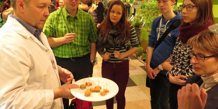 Mehrere Veranstaltungsbesucher stehen um den Anbieter von veganen Lebensmitteln.