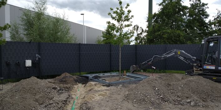 Einbau des Systems auf dem Firmengelände der Firma Humberg GmbH. Ein Bagger gräbt Erde zum Anlegen des Systems aus.
