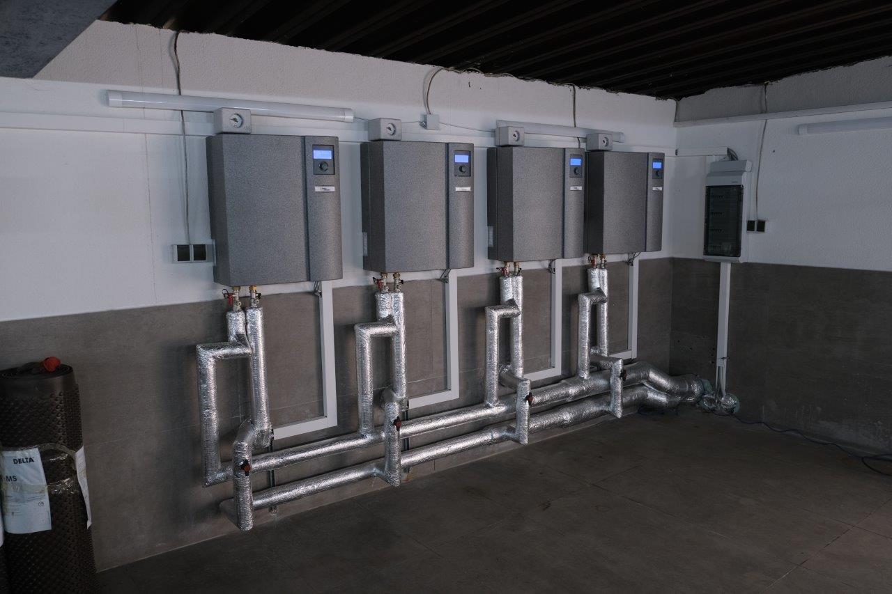 Die Kaskade aus den vier nebeneinander an der Wand montierten Reglern der Wärmepumpen im Heizungskeller.