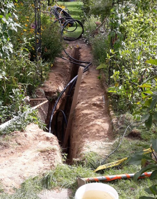 Ein PE-Rohr im offenen Graben für Erdwärme-Flachkollektor.
