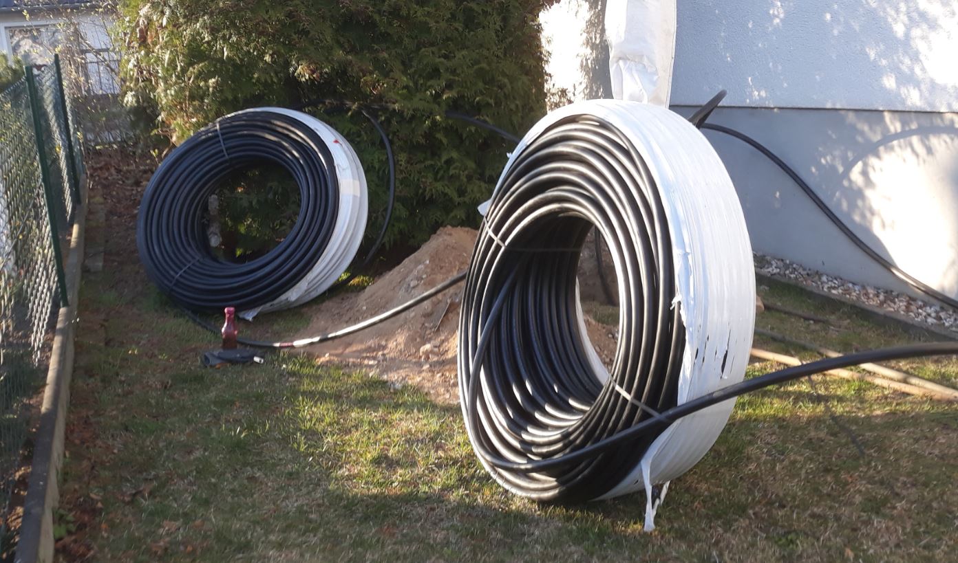Zwei PE-Rohr-Rollen für den Wärmekollektor auf der Wiese neben dem Haus