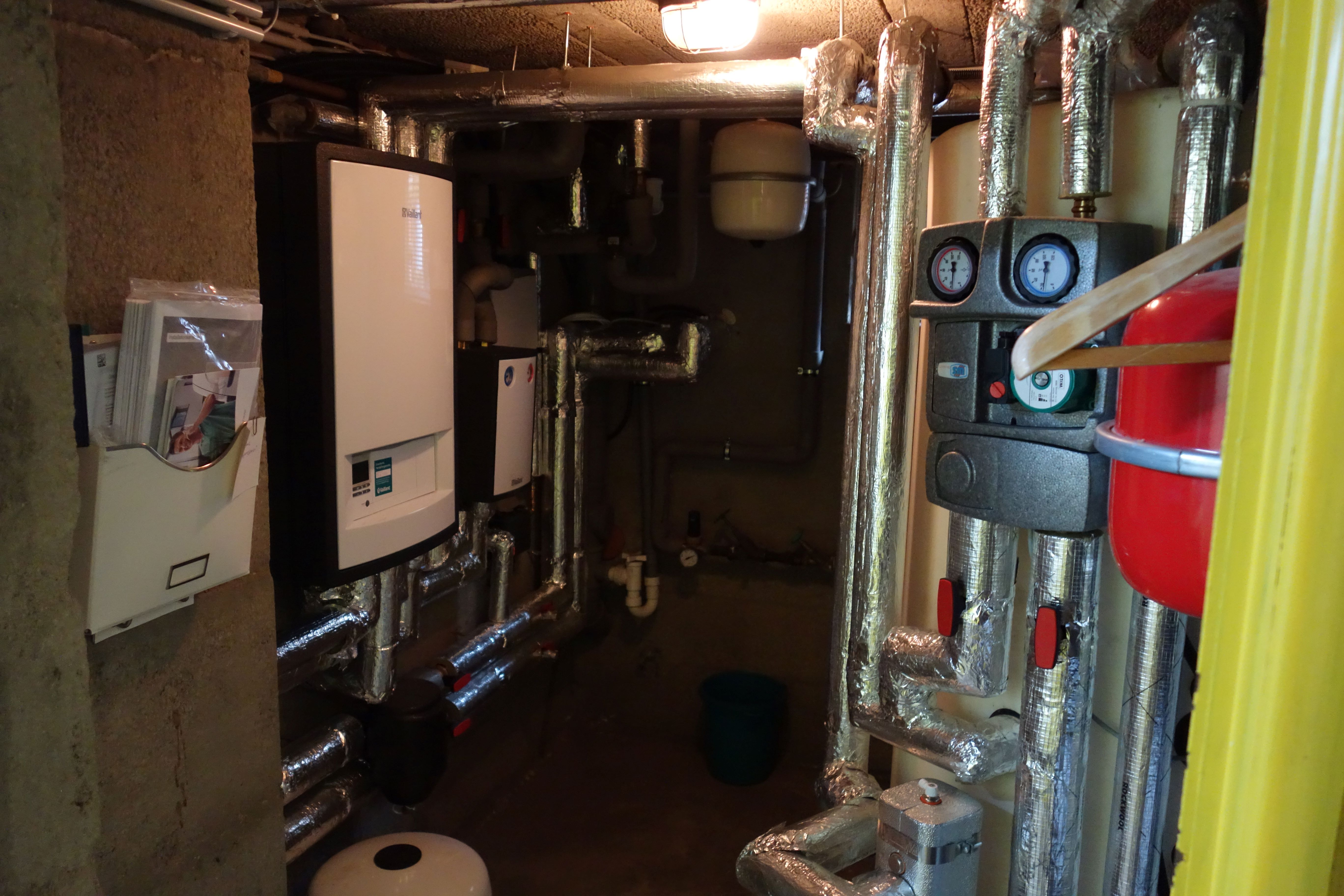 Ein Heizungskeller mit dem Innengerät Wärmepumpe, Pufferspeicher und gedämmten Leitungen..